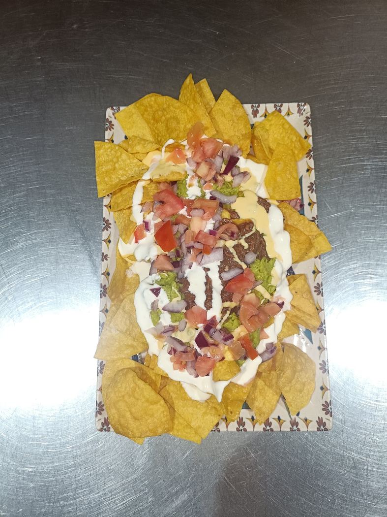 Nachos de la casa con carne picada, queso fundido y guacamole.